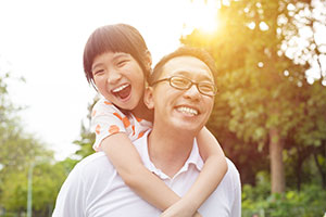 father carrying smiling daughter