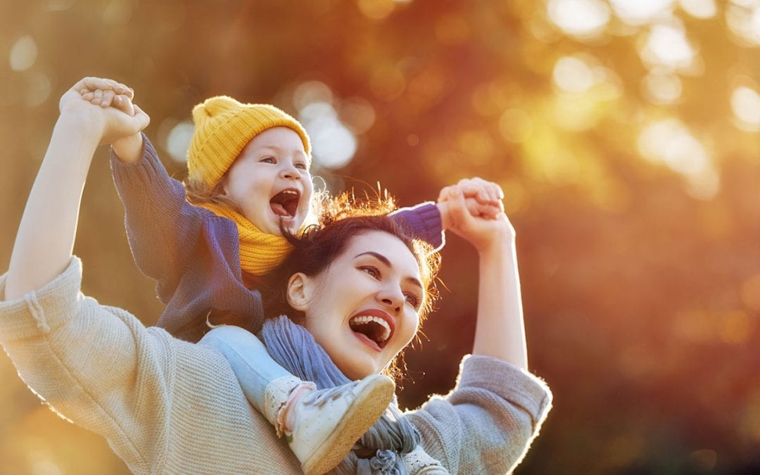 Mother Carrying Child on Autumn Walk