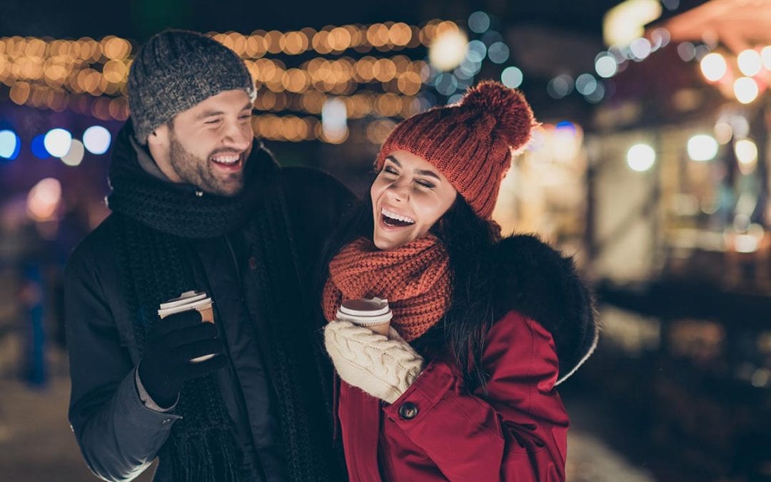 Two people with hot beverages outside in winter